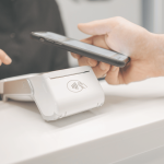 Person paying with their phone on a card machine